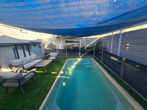 a swimming pool under a tent with a table and chairs at אחוזת ישי-אברהם in Tiberias