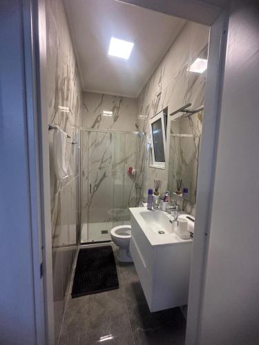 a bathroom with a shower and a sink and a toilet at Villa Julieta in Scalea