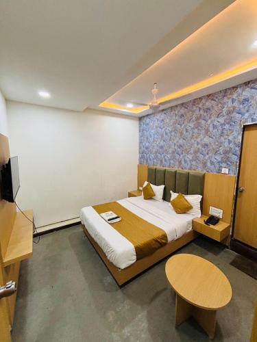 a bedroom with a large bed and a table at Hotel Sun Park in Ahmedabad