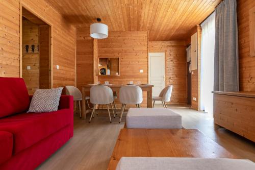 a living room with a red couch and a table at Résidence Odalys Les Chalets d'Evian in Évian-les-Bains