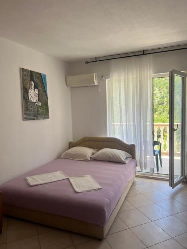 a large bed in a room with a window at Villa Đeković in Čanj