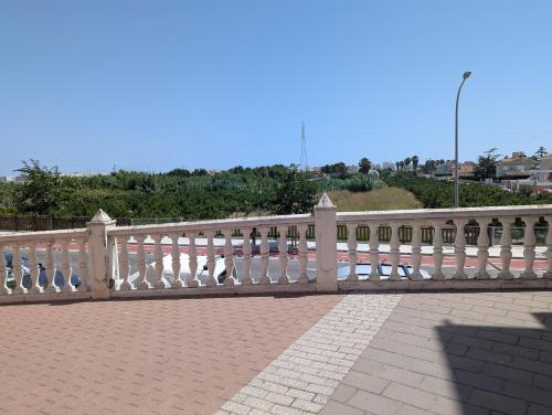 a white fence on top of a brick sidewalk at Ca TONI in Daimuz