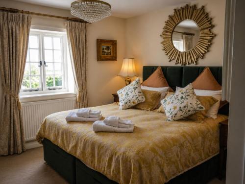a bedroom with a bed with towels on it at Lower Colworth Lodge in Chichester