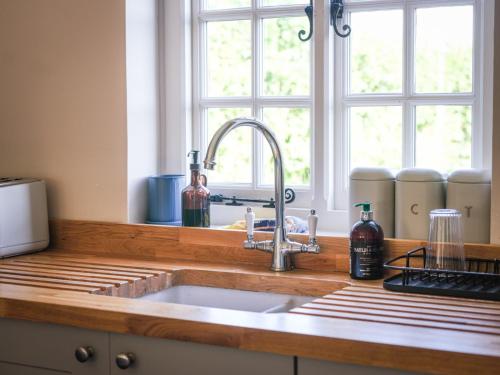 a kitchen counter with a sink and a window at Lower Colworth Lodge in Chichester