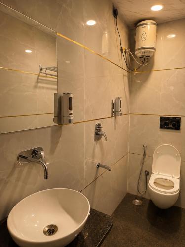 a bathroom with a white toilet and a sink at Hotel maharaja in Udaipur