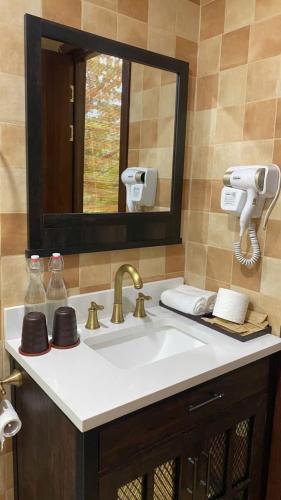 a bathroom with a sink with a mirror and a mirror at Con Nho RiverHouse Hue in Thôn Tiên Nộn
