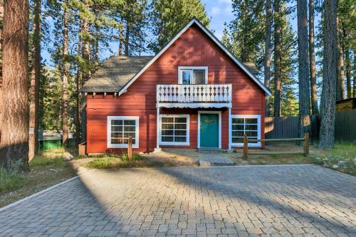 a red house with a blue door in the forest at 3664 Birch Avenue cabin in South Lake Tahoe