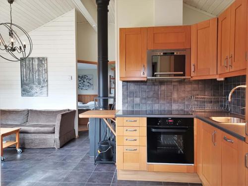 a kitchen with wooden cabinets and a stove at Cozy Cabin with Fireplace in Åre