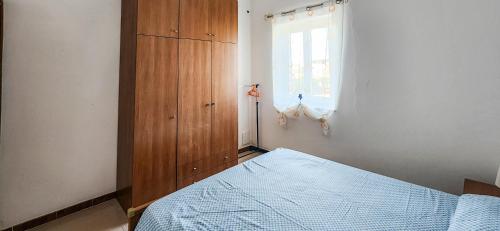 a bedroom with a bed and a wooden cabinet at Casa delle Farfalle in Cariati