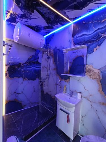 a bathroom with a white sink and a blue light at Family Hotel Casablanca Green in Varna City