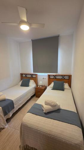 a room with two beds and a large screen at Vistamar -primera linea de playa in El Borseral