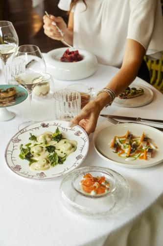 a person holding a plate of food on a table at Lido Palace - The Leading Hotels of the World in Riva del Garda
