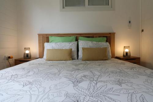 a bedroom with a large bed with two lamps at Joli Cocon in Baie-Mahault
