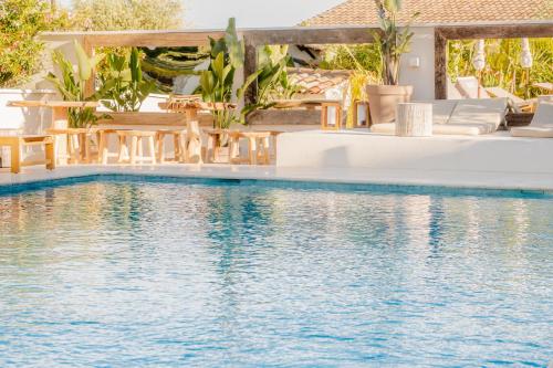 a swimming pool with chairs and tables next to the water at Auberge TAO in Biot