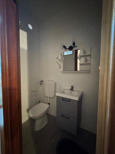 a white bathroom with a toilet and a sink at B&b Romani in Bologna
