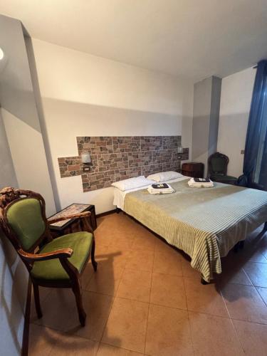 a bedroom with a bed and a green chair at B&b Romani in Bologna