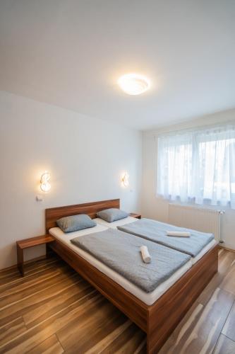 a bedroom with a large bed and a window at AH-Corso Wellness Apartment in Siófok