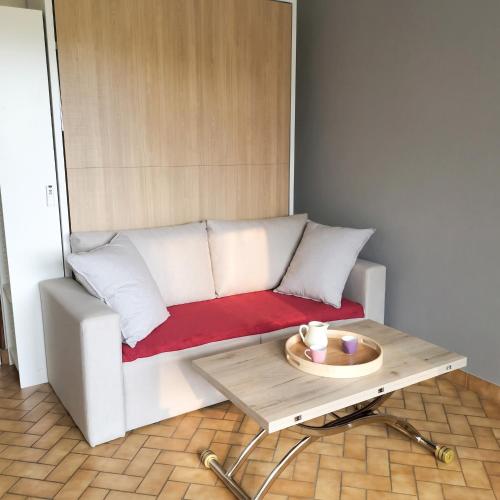 a white couch with a coffee table in a room at Studio cosy avec terrasse et barbecue à Cazaubon - 28 m² in Cazaubon