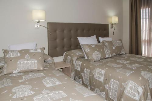 a bedroom with two beds and a headboard and a bed sidx sidx sidx sidx at Hotel Presa in Riaño
