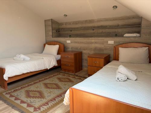 a bedroom with two twin beds and a rug at Yvette B&B in Garni