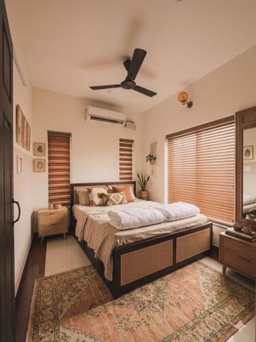 a bedroom with a large bed and a ceiling fan at J V A Home stay Apartment Hotel in Kollam