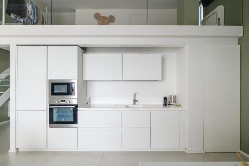 a white kitchen with a sink and a microwave at Montegrottone Nature Retreat in Polignano a Mare