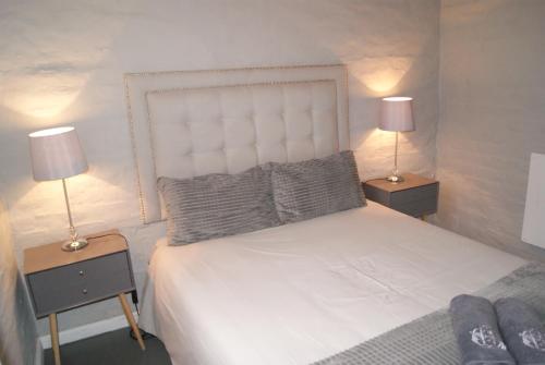 a bedroom with a white bed with two lamps at Chalet Eland in Ladismith