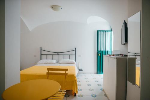a bedroom with a yellow bed and a table at Casetta Puntino in Atrani