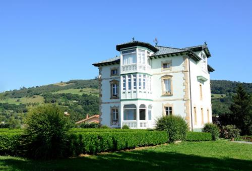 a large white house with a hill in the background at Hotel Rural El Solar del Mazo in Rada