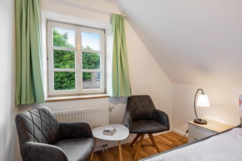 a bedroom with two chairs and a table and a window at Zeitlos Wriezen 2 in Wriezen