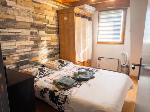 a bedroom with a bed and a stone wall at Appartement charmant à Sarzeau avec vue sur la mer, 55 m² in Sarzeau