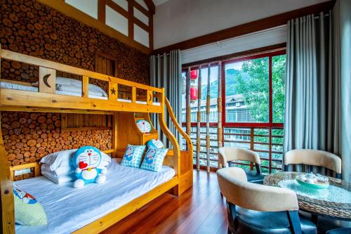 a bedroom with a bunk bed and a table at Zhangjiajie Cloudscape Courtyard Hotel-Vegan Available, Chinese Retro Style,Tea Culture Experience, Free Breakfast ,Travel Guide& Book Tickets,Friendly Host,Orient esthetics in Hanqiyu