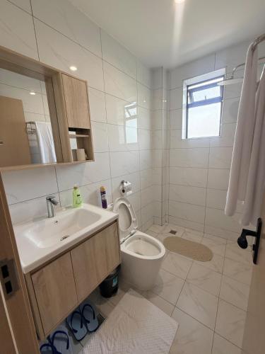 a white bathroom with a sink and a toilet at Rama Stays in Nairobi