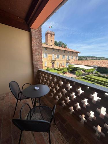 a patio with two chairs and a table on a balcony at Relais Castello di Razzano in Alfiano Natta