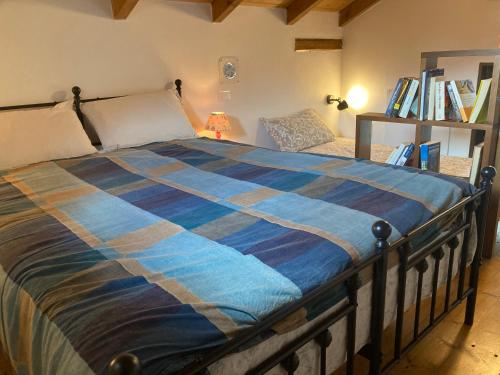 a bedroom with a bed with a blue comforter at B&B PETITE PROVENCE Genova in Ceranesi