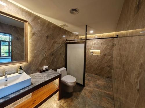 a bathroom with a toilet and a sink and a shower at The Moon Rabbit Resort Pai in Pai