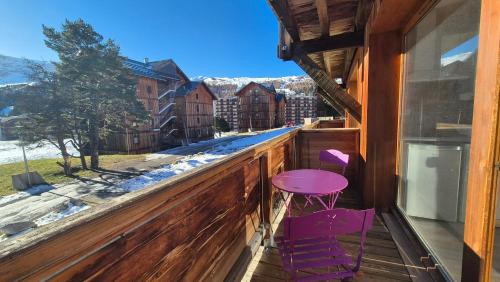 a porch with two purple stools and a window at Le Chalet de Super D in Le Dévoluy