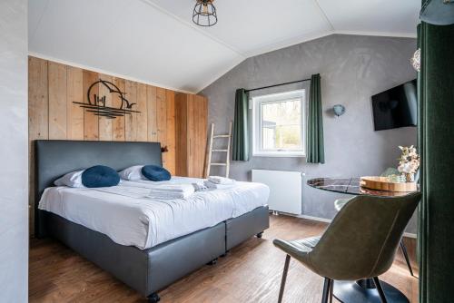 a bedroom with a bed and a table and chairs at Vakantiepark de Meerpaal in Zoutelande