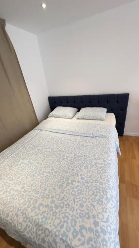 a bed with a blue headboard in a room at Modern Mini Apartment in Malmö
