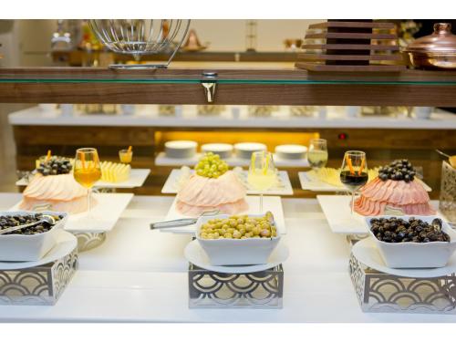 a table with plates of food and glasses of wine at Euphoria Batumi Convention & Casino Hotel in Batumi