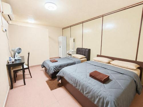 a room with two beds and a table and a desk at HM SweetRest HOTEL in Changlun