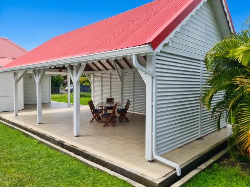 a pavilion with a table and chairs on a deck at Maison accueillante à Anse-Bertrand avec jardin privé 70 m² in Anse-Bertrand