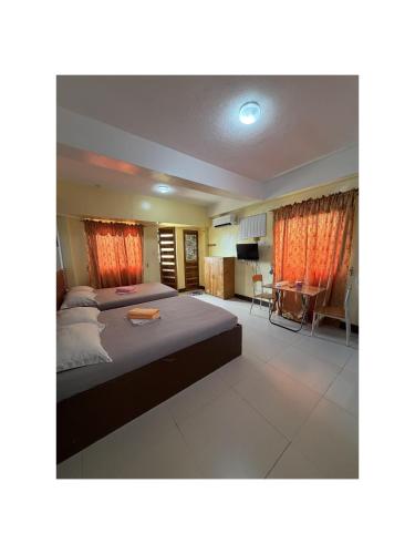 a bedroom with a large bed and a desk at Mayon Lodging House in Legazpi