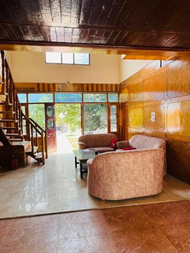 a living room with two couches and a table at AP cottage and huts in Manāli