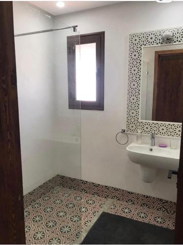 a bathroom with a sink and a mirror at Dar amiratt in El Guecheïne
