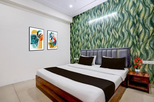 a bedroom with a large bed with a green wallpaper at Hotel Palm Paradise in Noida