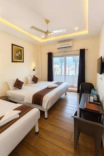 a hotel room with two beds and a desk at Hotel Lake Star Bistro in Udaipur
