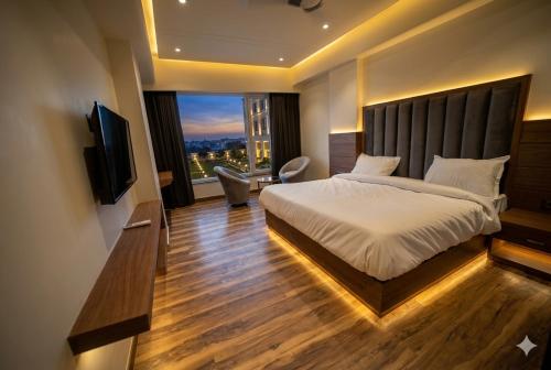 a bedroom with a large bed and a television at Hotel The Sawai in Jaipur