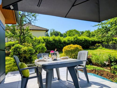 a blue table and chairs on a patio at VILLA climatisée - 4 étoiles - 75 m2 avec Jardin pour 3 personnes - à 10 min de Besançon in Dannemarie-sur-Crête