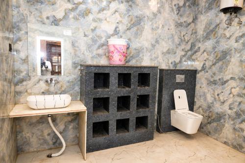 a bathroom with a sink and a toilet at Hotel Ramkesarrai in Ayodhya